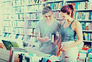 Girl and boy teenagers in book store