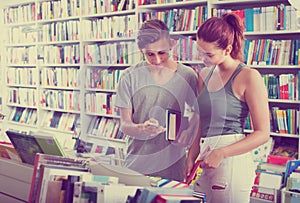 Girl and boy teenagers in book store