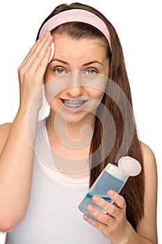 Girl with braces cleaning face isolated