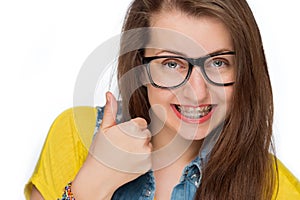 Girl with braces show thumb up isolated