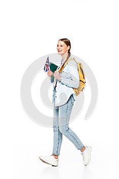 Girl with braid and backpack walking with flag of united kingdom and copybooks isolated on white