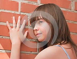 The girl at a brick wall