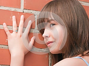 The girl at a brick wall