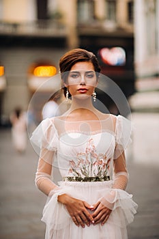 Girl-bride wedding dress with a beautiful floral pattern in Florence, stylish bride in a wedding dress stands in the Old city of