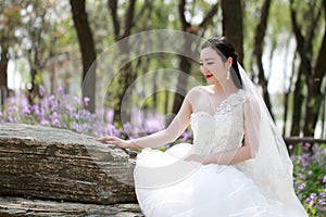Girl bride in wedding dress with elegant hairstyle, with white wedding dress in Green plants field