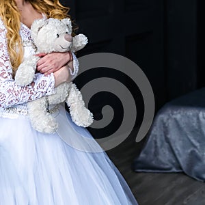 Girl-bride in a wedding dress with an object in her hands