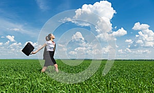 Girl with a briefcase walking on grass