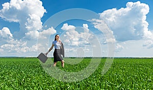 Girl with a briefcase walking on grass