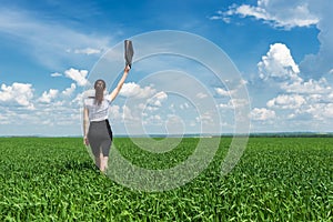 Girl with a briefcase walking on grass