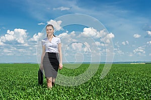 Girl with a briefcase walking on grass