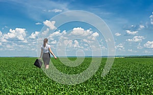 Girl with a briefcase walking on grass