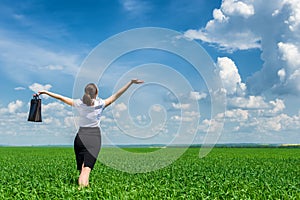 Girl with briefcase walking on the grass