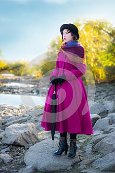 Girl in a bright crimson coat looks into the distance