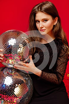 Girl with bright makeup holds a disco ball