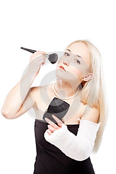 Girl with a broken arm trying to put makeup