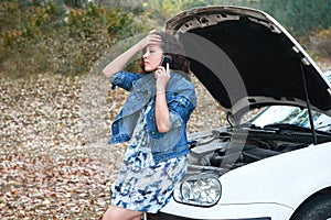 Girl with a broken car, open the hood, call for help