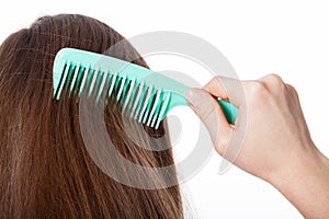 Girl with brown hair combing herself