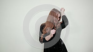 Girl brown haired in black dress over isolated white background shows emotions