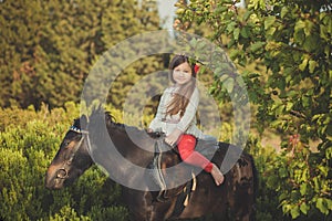 Girl with brunette hair and brown eyes stylish dressed wearing rustic village clothes white shirt and red pants on belt posing wit photo