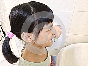 Girl brushing teeth earnestly