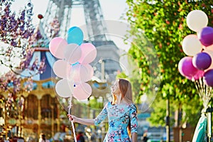 Girl with bunch of balloons in front of the Eiffel tower in Paris