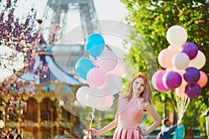 Girl with bunch of balloons in front of the Eiffel tower in Paris