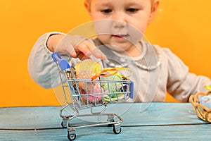 A girl with bunny ears puts dyed Easter eggs in a cart and deliv