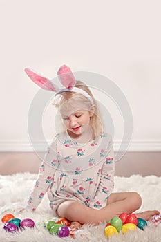 Girl with bunny ears and toys eggs celebrating Easter holiday