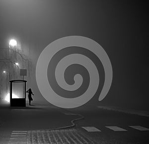 Girl at bus stop at night