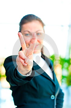 Girl in a business suit showing gesture - victory hand