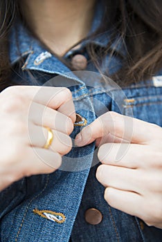 Girl is button up her Denim jacket