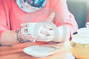 Girl in a cafe with a cup of tea and drinking hot herbal tea. fr