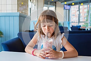 A girl in a cafe, drinking a milkshake. Healthy food