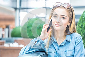 Girl calling with the smart phone in a shpping mall sitting in internet free zone photo