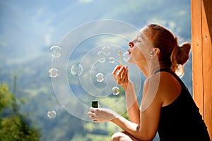 A girl in a calm mood blows bubbles overlooking photo