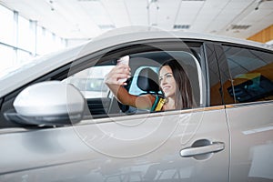A young girl chooses a new car for herself. Buying a new car.