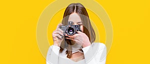 Girl with a cameras. Woman holding camera over yellow background. Girl using a camera photo. Photographer camera photo