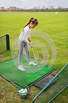 Girl with cammock traines of hit in green golf photo