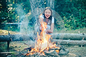 Girl camping with marshmallows over a camp fire. Girl enjoying picnic in the forest. Vacation weekend picnic camping and