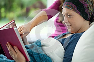 Girl with cancer holding photo album