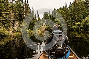 Girl canoeing with Canoe on the lake of two rivers in the algonquin national park in Ontario Canada on cloudy day