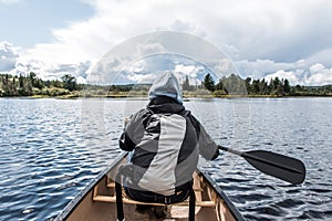 Girl canoeing with Canoe on the lake of two rivers in the algonquin national park in Ontario Canada on sunny cloudy day