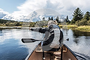 Girl canoeing with Canoe on the lake of two rivers in the algonquin national park in Ontario Canada on sunny cloudy day