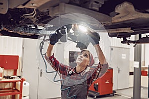 Girl in a cap holding car tools