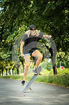 Girl in a cap performs a skateboard trick