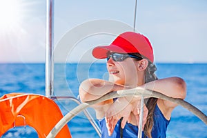 Girl captain on board of sailing yacht on summer cruise. Travel adventure, yachting with child on family vacation.