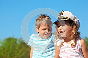 Girl with captain cap and boy at sunny day