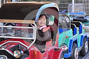 A girl on a car in an amusement park