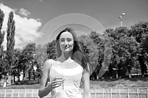 Girl cares about body hydration during workout. Thirsty woman holds water bottle. Thirst and water balance concept