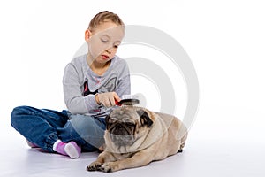 The girl cares for the dog, listens to a stethoscope.
